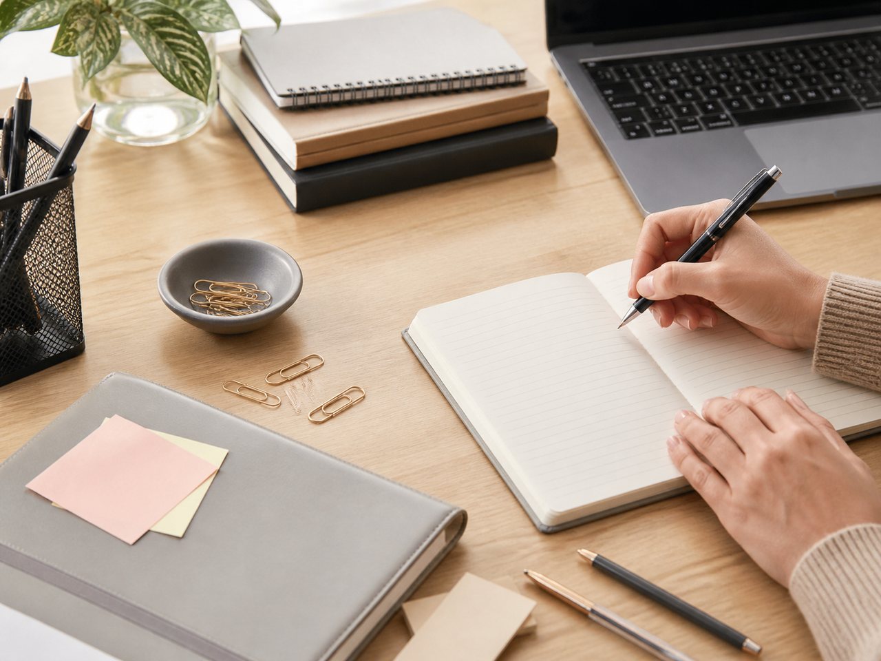 Mesa de oficina con cuaderno, portátil y papelería